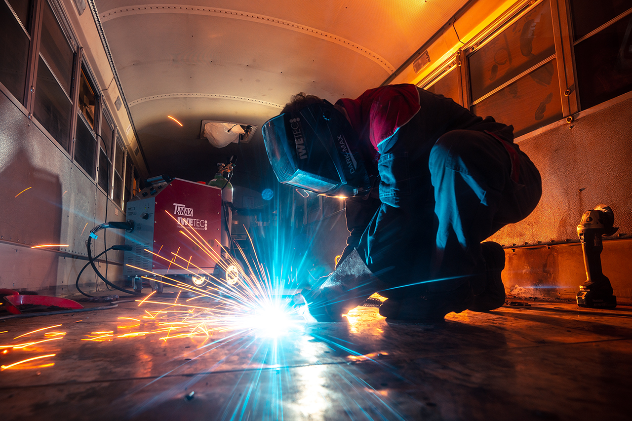 The worker is welding with sparkles splashing
