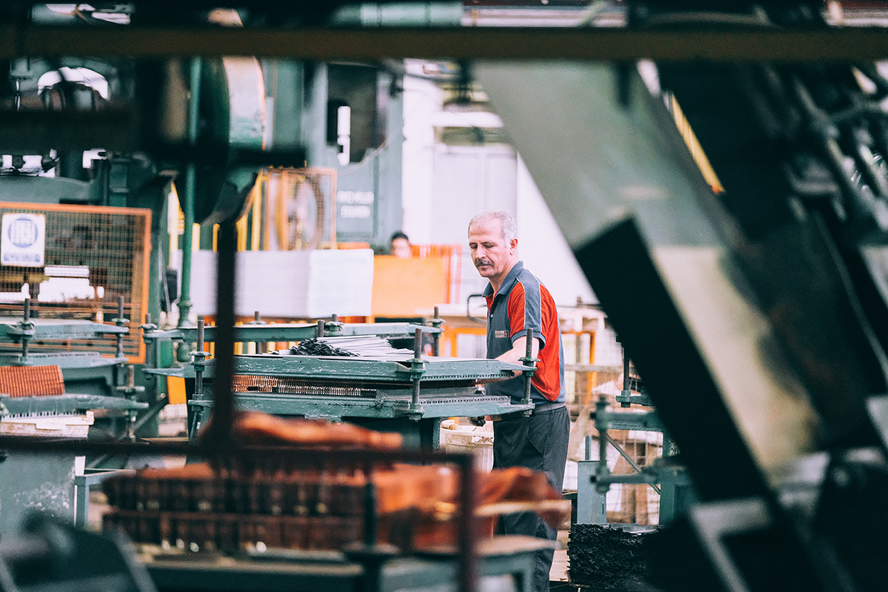 A grey hair worker works in the manufacture factory