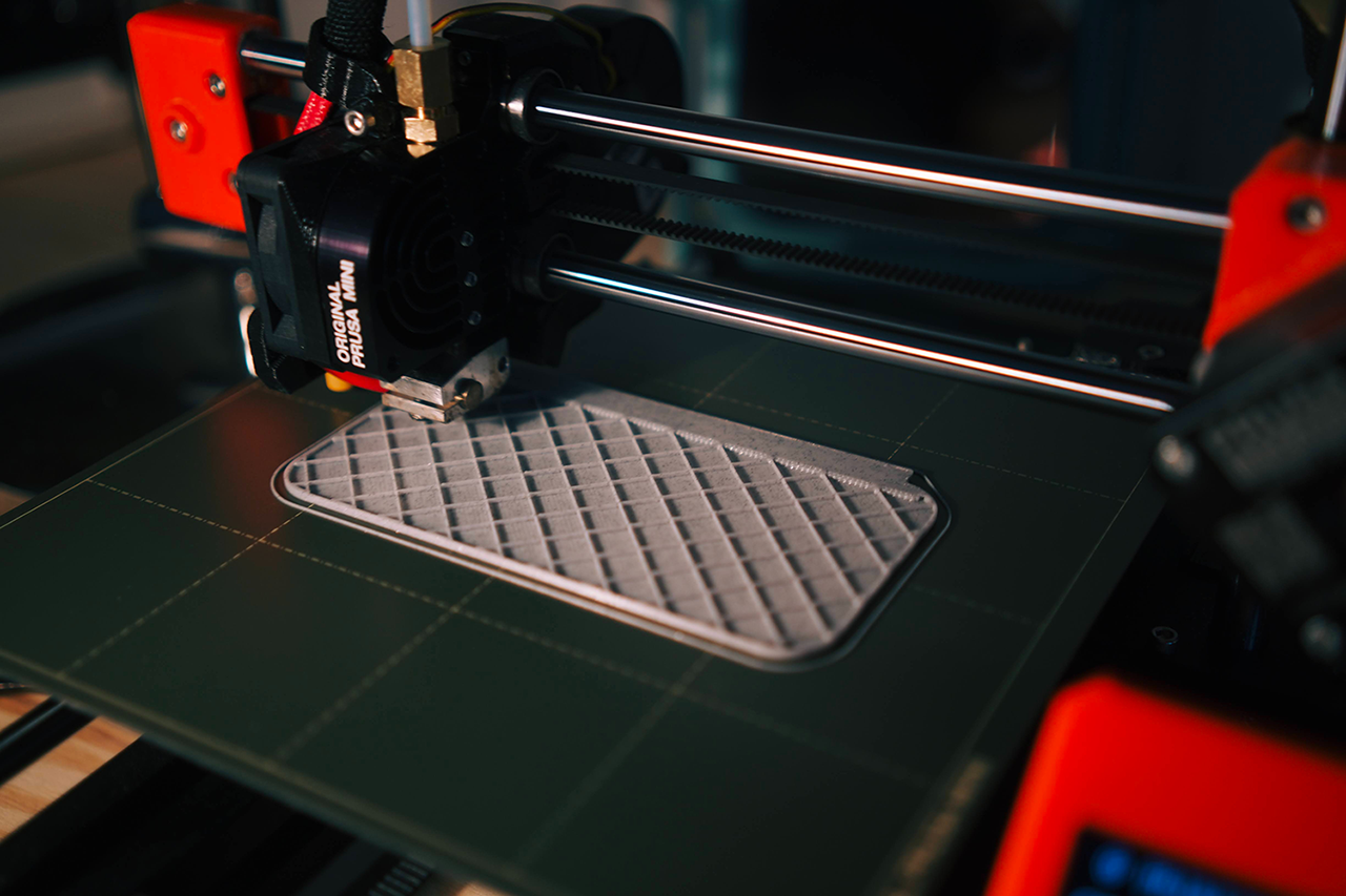 The 3D printer prints a gray flat grid